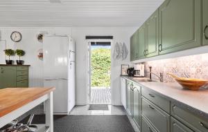 a kitchen with green cabinets and a white refrigerator at 3 Bedroom Beautiful Home In Gilleleje in Gilleleje