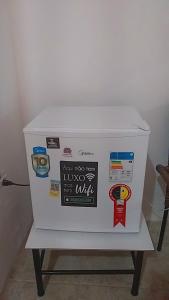 a white cooler sitting on a table with stickers on it at Pousada vitoria praia de serrambi-pe in Ipojuca +17 photos
