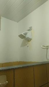 a white wall with a hair dryer on the wall at Pousada vitoria praia de serrambi-pe in Ipojuca