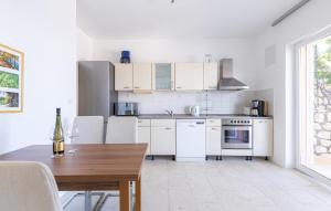 a kitchen with white cabinets and a wooden table at 2 Bedroom Lovely Apartment In Lukovo in Lukovo