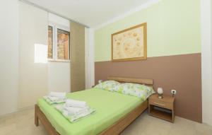 a small bedroom with a green bed and a table at 2 Bedroom Lovely Apartment In Lukovo in Lukovo