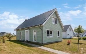 a green house with a gray roof on a yard at Awesome Home In Ostseeresort Olpenitz in Olpenitz +38 photos