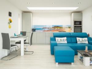 Una sala de estar con un sofá azul y una mesa. en 1 Bed in Woolacombe 52914, en Ilfracombe
