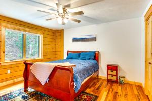 a bedroom with a bed and a ceiling fan at Mtn-View Deck Scenic Conway Log Cabin! in Conway