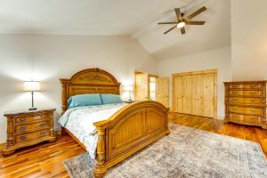 a bedroom with a wooden bed and a ceiling fan at Mtn-View Deck Scenic Conway Log Cabin! in Conway