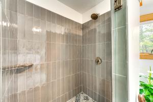 a bathroom with a shower with gray tiles at Mtn-View Deck Scenic Conway Log Cabin! in Conway +28 photos