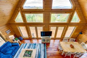 a living room with a wooden ceiling with windows at Mtn-View Deck Scenic Conway Log Cabin! in Conway