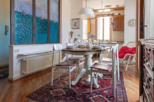 デセンツァーノ・デル・ガルダにあるLa Chicca sui Tetti Centro&Lago By Case al Lagoのテーブルと椅子のあるキッチンとダイニングルーム