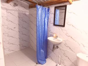 a bathroom with a blue shower curtain and a sink at hotel campestre san antonio in Campoalegre