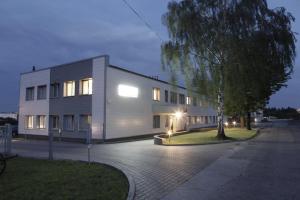 un edificio con un árbol delante de él en Standard Delegacyjny Bed & Breakfast, en Dąbrowa Górnicza