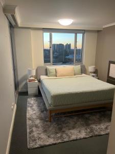 a bedroom with a bed and a large window at Darling Harbour Luxurious Retreat in Sydney
