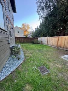 a backyard with a fence and a grate in the grass at Family Comfy Kid Family Pet-Friendly Home Near Everything in Issaquah