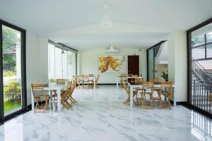 a dining room with tables and chairs and windows at Canopy Villa Cay Sao in Phu Quoc