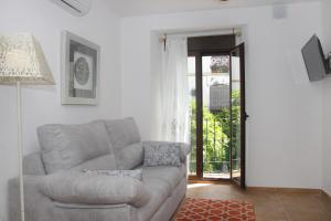 - un salon avec un canapé et une porte ouverte dans l'établissement Apartamentos San Fernando 76, à Cordoue