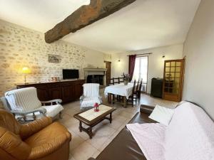 een woonkamer met een bank en een tafel bij Maison spacieuse près du Perche avec jardin et WIFI gratuit - FR-1-497-124 in Bures