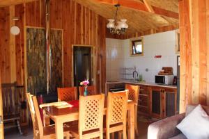 a kitchen and dining room with a table and chairs at Cabaña Rinconada de Malalcahuello in Malalcahuello
