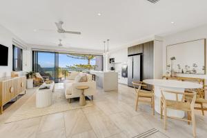 黄金海岸Escape 201的开放式厨房以及带桌椅的客厅。