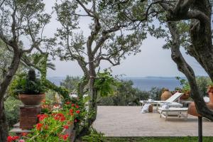 a patio with a table and chairs and flowers at Villa Sofia in Massa Lubrense
