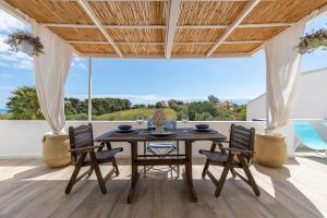 サンタ・マリア・デル・フォカッロにあるRomantic House terrazza vista mareのテーブルと椅子のあるダイニングルーム