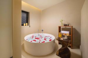 Nice holiday Resort-Guanhu beach Shenzhen في شنجن: حمام به حوض استحمام كبير مزين بالزهور الحمراء