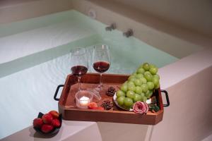 Nice holiday Resort-Guanhu beach Shenzhen في شنجن: صينية من كؤوس النبيذ والفواكه في حوض الاستحمام