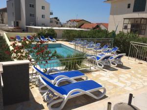 巴什卡沃達的住宿－多里基尼多沃里酒店，一组蓝色的躺椅,位于游泳池旁