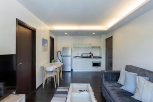 un salon avec un canapé et une table dans l'établissement Modern apartment at The Title by Lofty, à Ban Saiyuan (1)