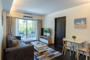 un salon avec un canapé et une table dans l'établissement Modern apartment at The Title by Lofty, à Ban Saiyuan (1)