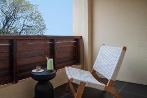 Nice holiday Resort-Guanhu beach Shenzhen في شنجن: شرفة مع كرسيين وطاولة ونافذة