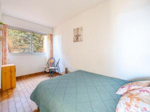 a bedroom with a bed and a chair and a window at Appartement 8 personnes, vue mer, Wi-Fi illimité - FR-1-827-29 in Roquebrune-Cap-Martin
