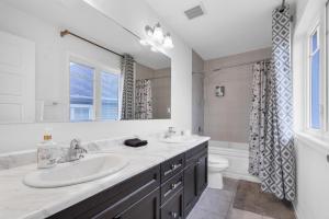 a bathroom with two sinks and a toilet at 4BR 2 king 3 Queen 6 beds in total 3 GBPS Wi-Fi in Kitchener +45 photos