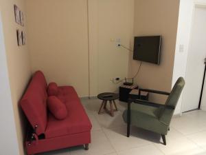 a living room with a red couch and a television at Dpto San Javier in Yerba Buena