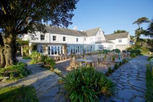 un grande edificio bianco con tavoli e sedie di Talland Bay Hotel, Looe a Talland