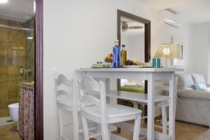 - une cuisine avec une table blanche et des chaises blanches dans l'établissement Apartamentos San Fernando 76, à Cordoue 83 autres photos