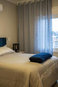 a bedroom with a bed with a blue pillow on it at apto Casal Canela in Canela