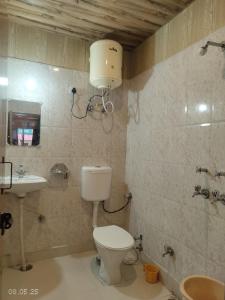 a bathroom with a toilet and a sink at Gokul Guest House By Mero Pahad Stays & camp in Pāndukeshwar