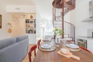 Un comedor con una mesa y un sofá. en Rooftop Nest in Como city center by Rent All Como, en Como
