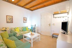 a living room with a couch and a table at Villa Maistro Cottage by Villa Plus in Ágios Stéfanos