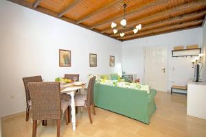 a dining room with a table and a couch at Villa Maistro Cottage by Villa Plus in Ágios Stéfanos