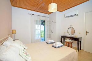 a bedroom with a bed with a desk and a mirror at Villa Maistro Cottage by Villa Plus in Ágios Stéfanos +9 photos