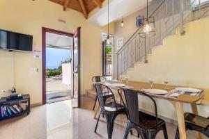 a dining room with a table and chairs and a staircase at Villa Anna Lefkas in Póndi