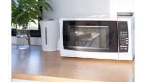 un forno a microonde seduto sopra un pavimento in legno di Kawal Tiny House by Tiny Away a Wollombi