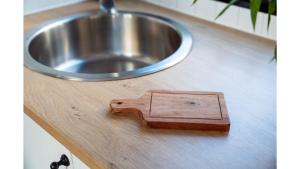 un blocco di legno su un bancone accanto a un lavandino di Kawal Tiny House by Tiny Away a Wollombi Altre 27 foto