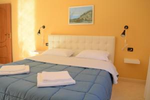 1 dormitorio con 1 cama grande y 2 toallas. en Villa Basilika, en Vlorë