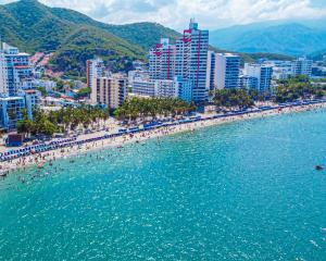 a beach in a city with people in the water at Azure apartahotel in Santa Marta +184 photos