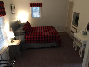 a bedroom with a bed and a couch and a table at Mcleod Cottage in Norway