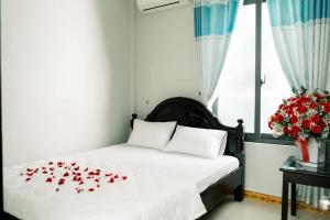 - une chambre avec un lit orné de roses rouges dans l'établissement Homestay Be, à Hue