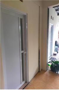 an empty room with an open door with a plant at Ngijo Homestay Kost TaniaAlexa in Srondolwetan