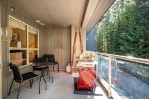 a small balcony with a table and chairs and a window at Aspens Lodge 220 by Outpost Whistler in Whistler