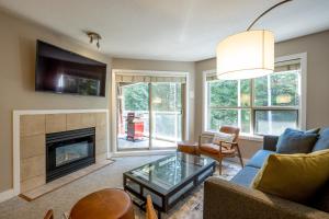 a living room with a couch and a fireplace at Aspens Lodge 220 by Outpost Whistler in Whistler